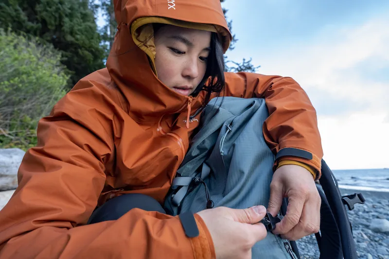 Hiker adjusting a technical backpack by the coast